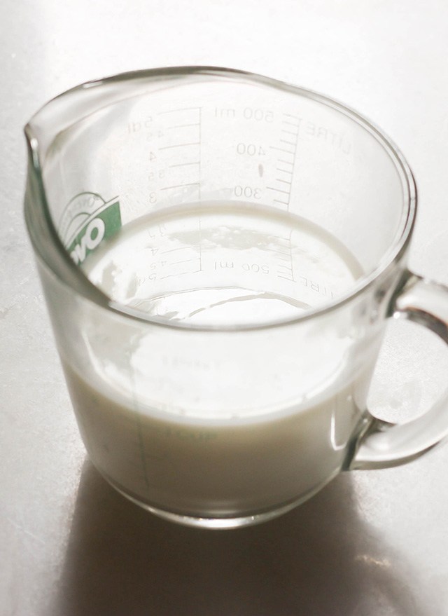 cup of homemade buttermilk on a marble counter