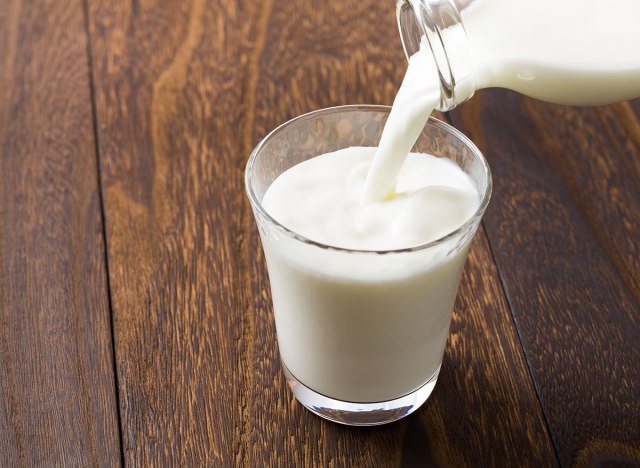 glass of milk being poured from glass jar