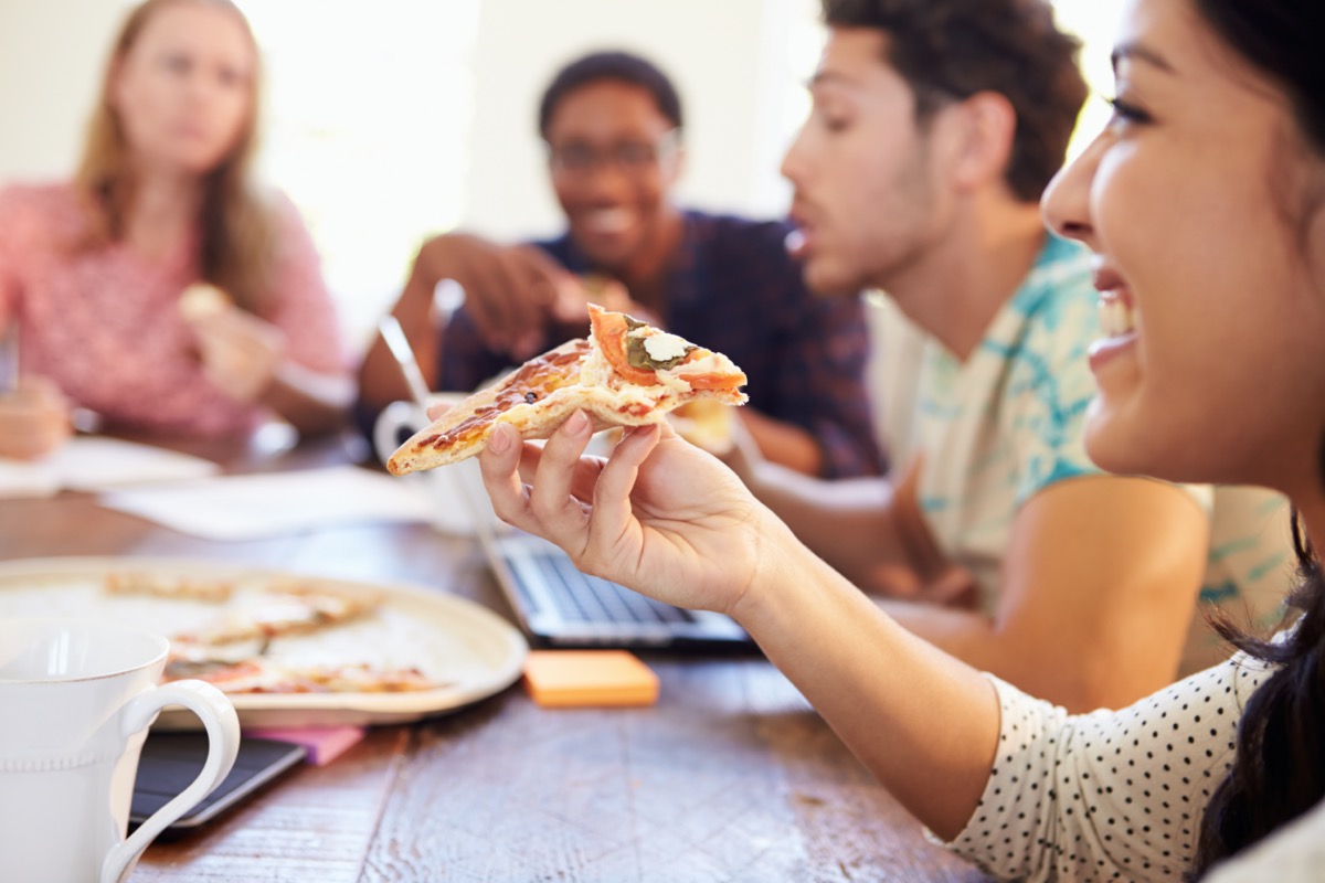 business people having a meeting and eating pizza