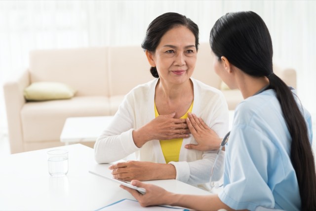 general practitioner and her elderly patient talking about heart disease