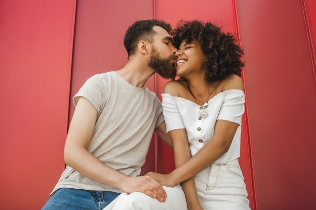 handsome young man kissing happy girlfriend