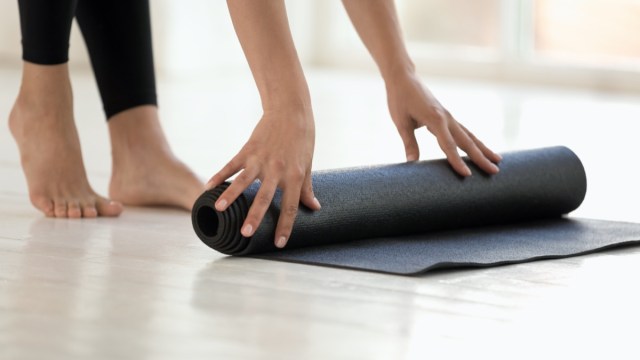 Woman wearing black leggings finished or starting workout rolling mat