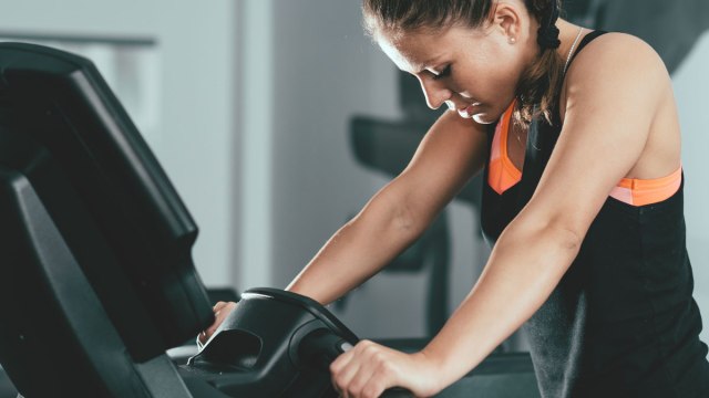 tired woman at gym struggling to finish treadmill workout