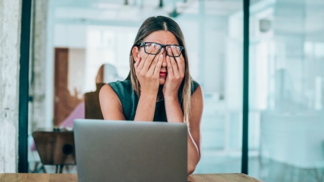 stressed businesswoman rubbing her eyes in the office.