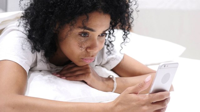 woman on phone in bed