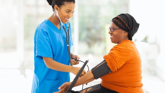 nurse checking woman's blood pressure