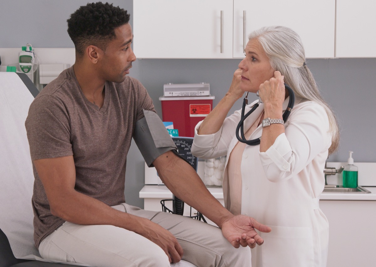 female doctor checking the blood pressure of male patients at the clinic