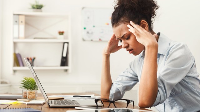 stressed out young woman sitting at desk