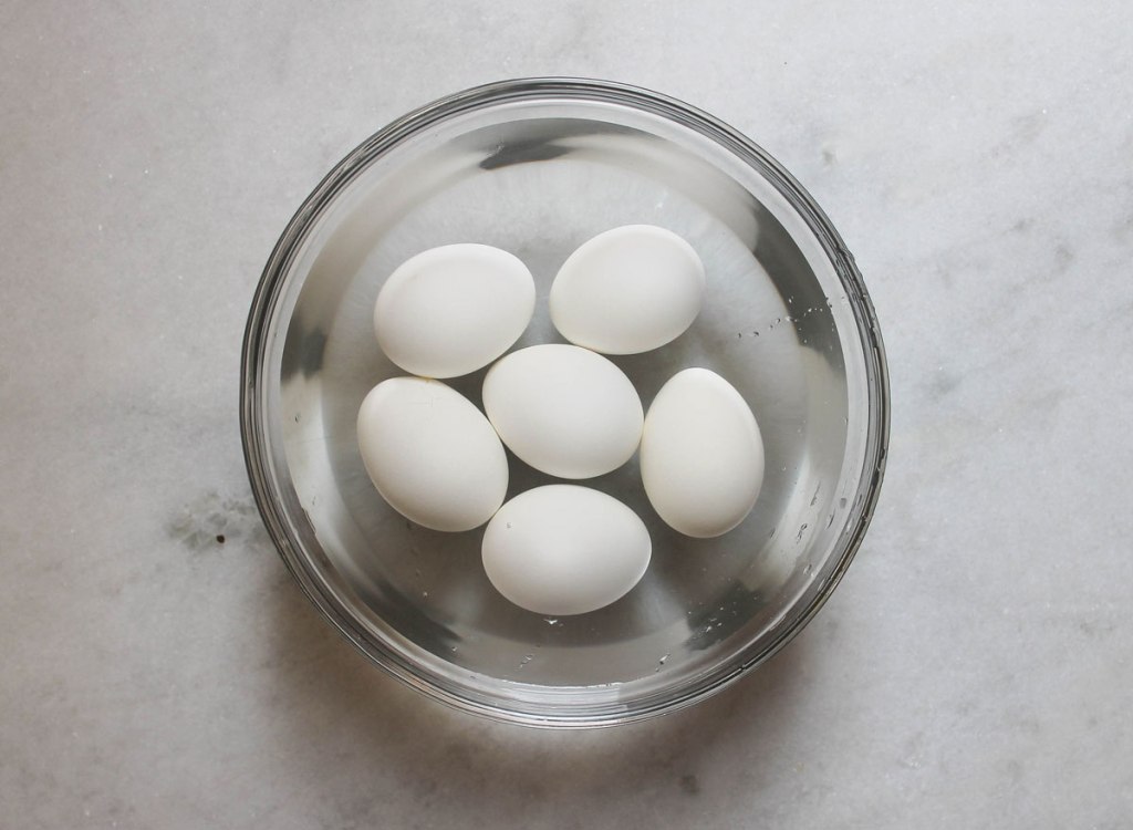 Eggs in cold water before peeling in a bowl