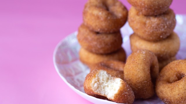 mini doughnuts on white plate with pink background