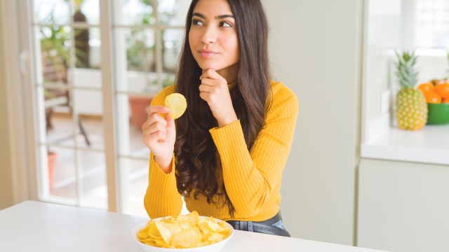 woman thinking about eating a potato chip and practicing conscious food