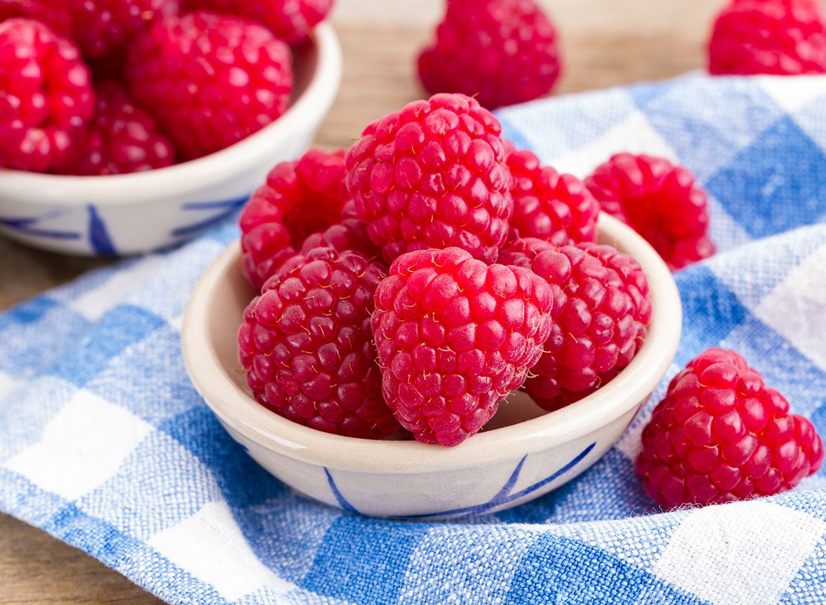 raspberries in the bowl on checkered cloth