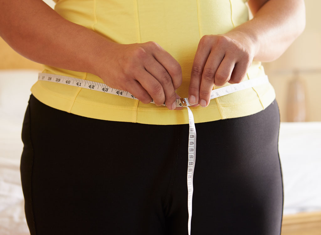 woman measuring her waist