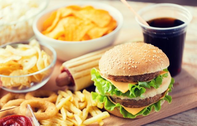 burgers or cheeseburgers, fried squid rings, french fries, drinks and ketchup on wooden tables
