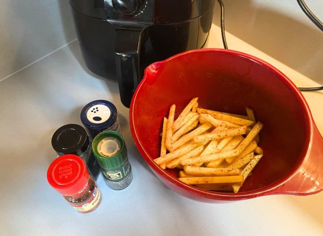 seasoned french fries in a red bowl