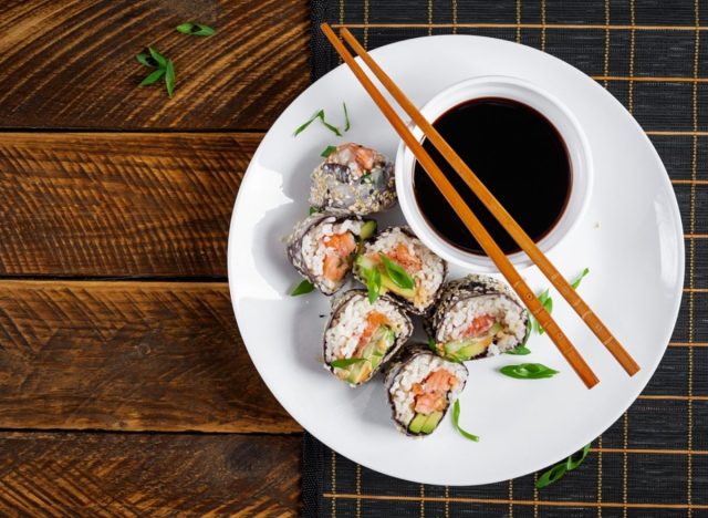 a plate of salmon sushi roll with soy sauce