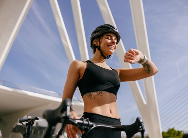 happy woman checking fitness tracker