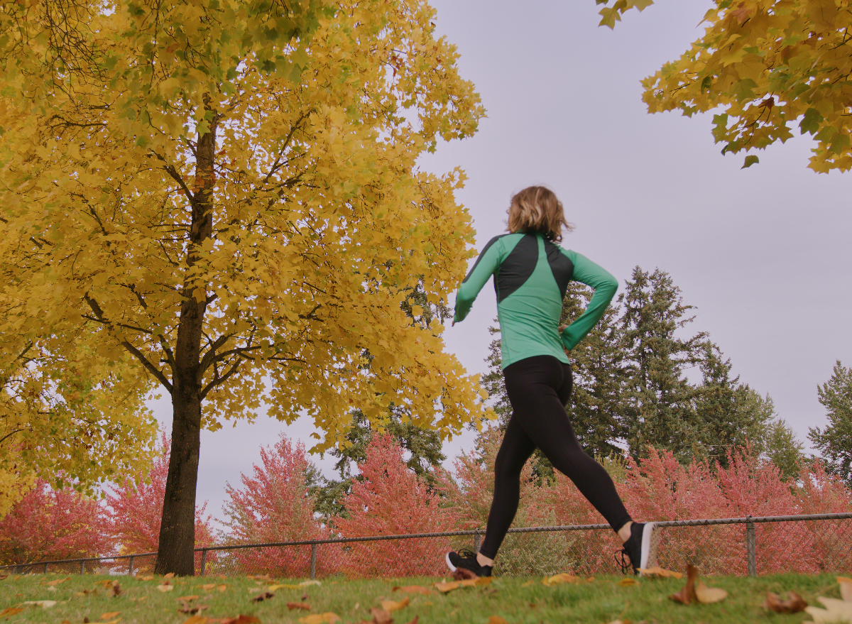 woman walking among autumn foliage, shows centurion race walking