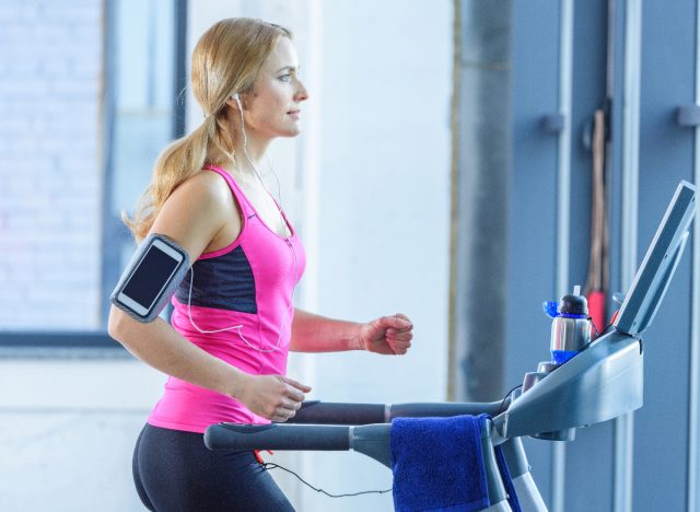 fit blonde woman doing treadmill incline walking exercise