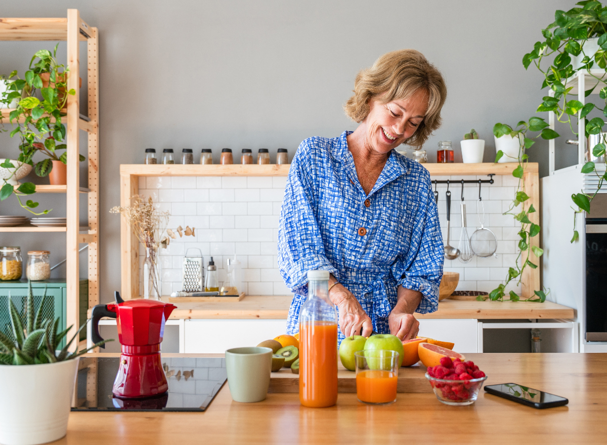 woman preparing healthy meal in bright kitchen, the concept of feeling relaxed at 50