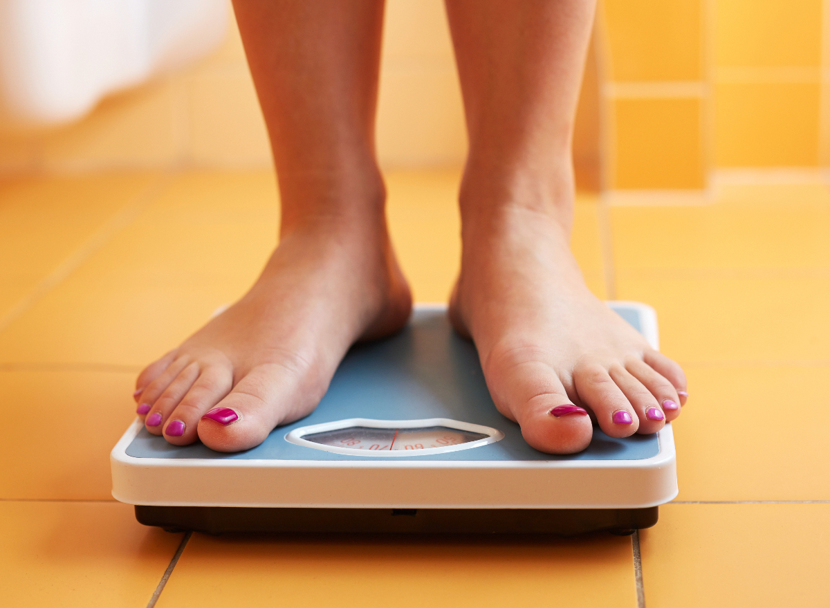 woman's feet on scale, concept of how to lose a pound