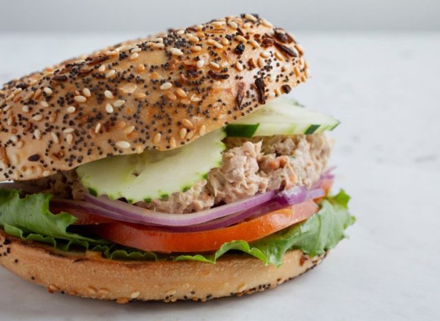 tuna salad on an everything bagel with veggies