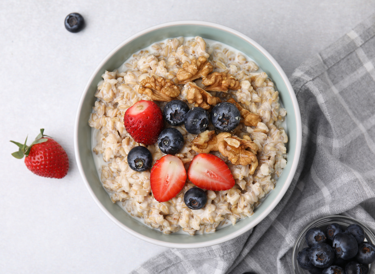 bowl of steel-cut oats turned into oatmeal topped with blueberries and strawberries