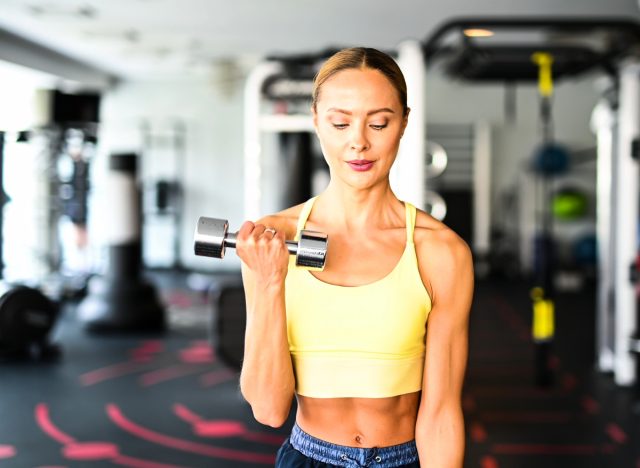 toned woman lifting weights, the concept of the 4-1-1 training method for fat loss