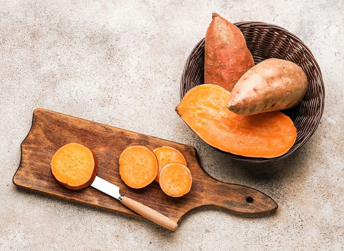 composition with fresh sweet potatoes on light background