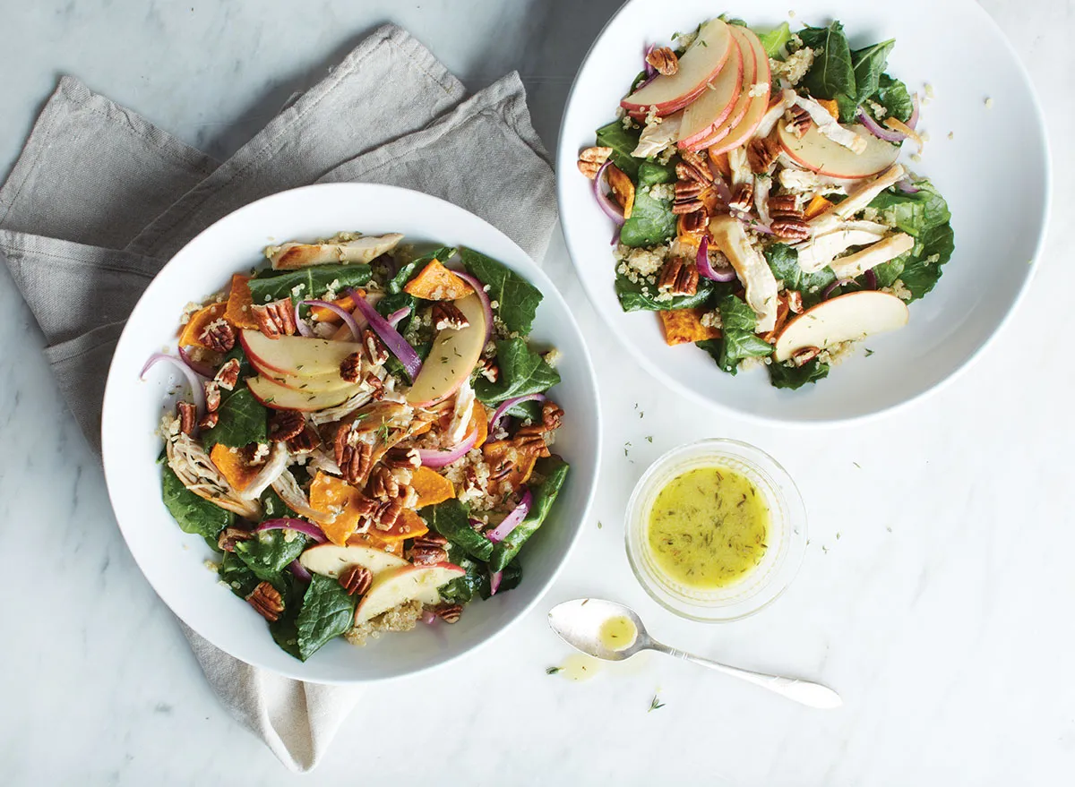 kale quinoa salad with apples and walnuts in two white bowls