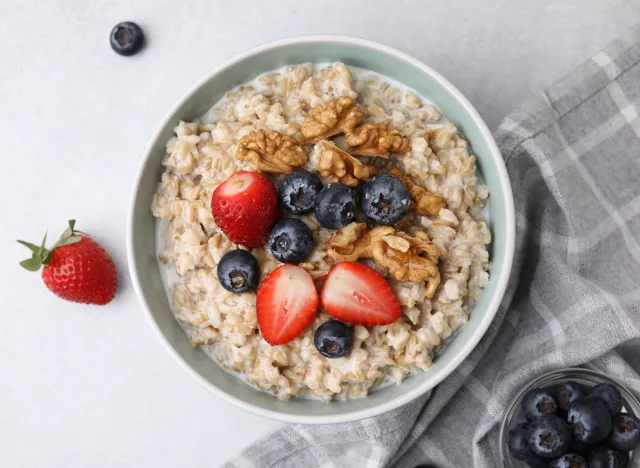 9 foods that function as natural weight loss aids 39 bowl of steel-cut oats turned into oatmeal topped with blueberries and strawberries