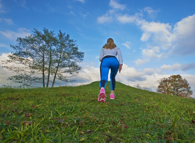 woman doing uphill walking exercise to shrink belly fat faster