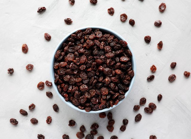 dried brown raisins in a bowl, top view. flat lay, top view.