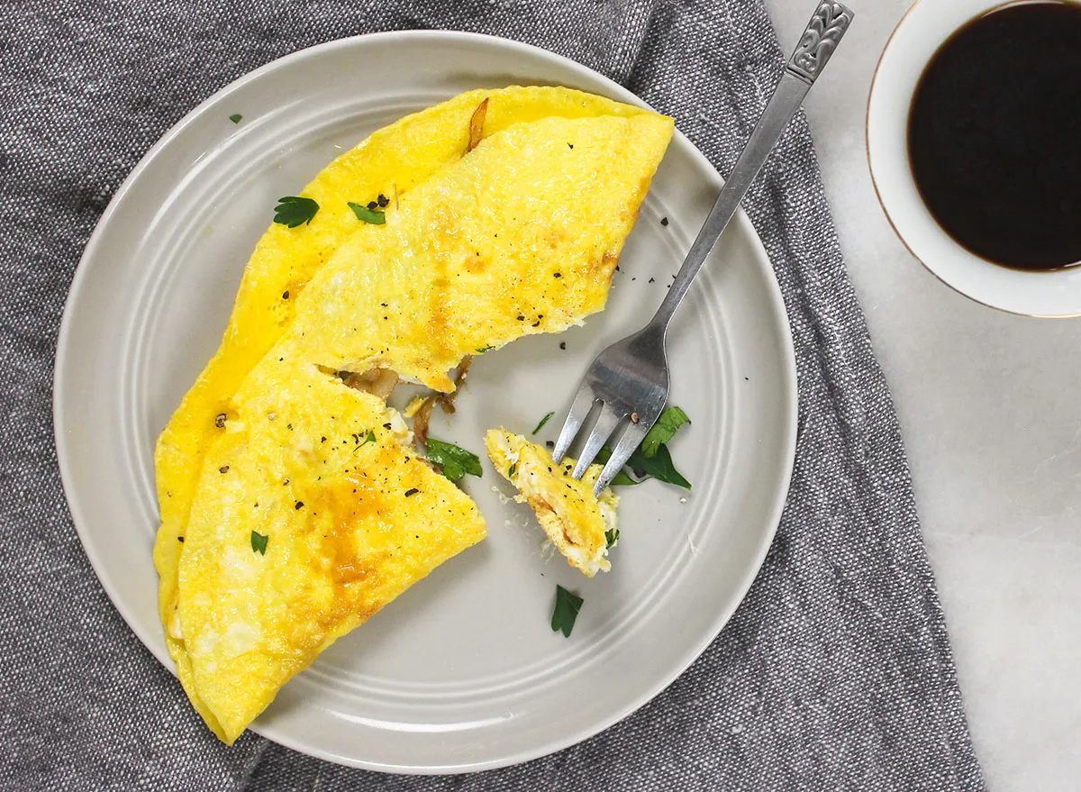 break into a cooked omelette on a gray plate