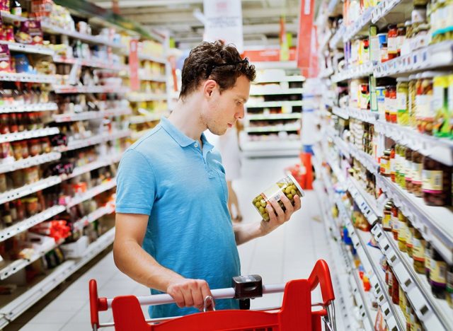 man reading food labels at supermarket