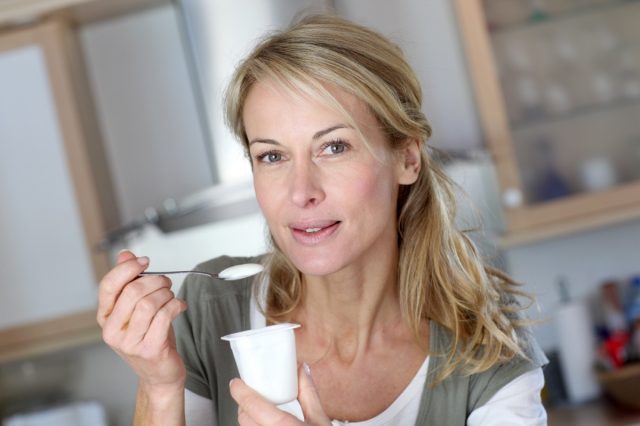 middle-aged woman enjoying yogurt