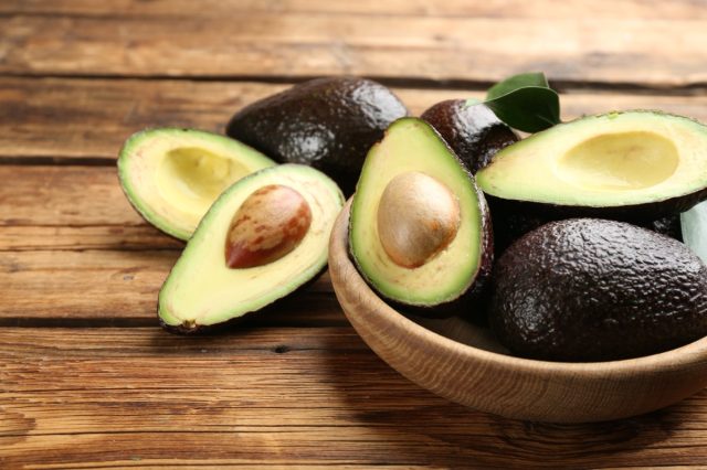 9 breakfast foods that help burn visceral fat throughout the morning 7 whole and cut off avocado on wooden tables, close -up