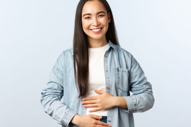 happy woman placing hands on her stomach