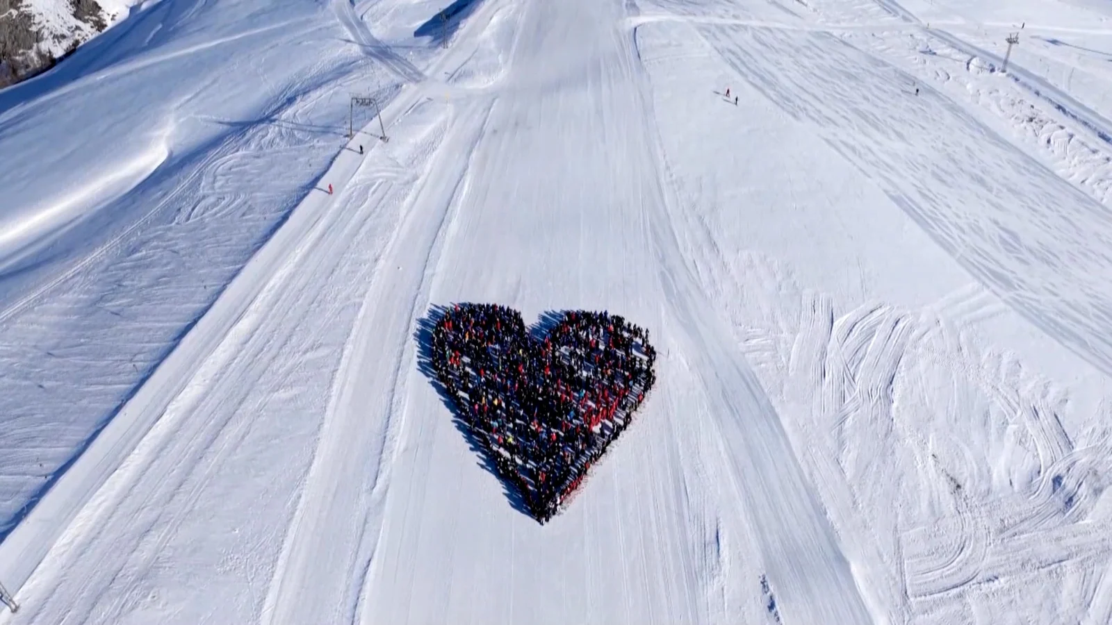 Video: Skiers carve heart-shaped tribute honoring Swiss fire victims