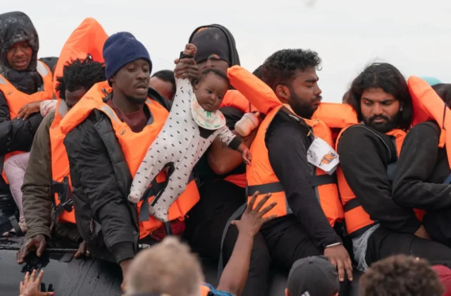 Months-old baby seen hauled onto UK-bound migrant dinghy as French police stand by